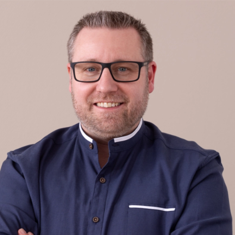 Porträt eines lächelnden Teammitglieds der AFMO eG im grauen Sakko