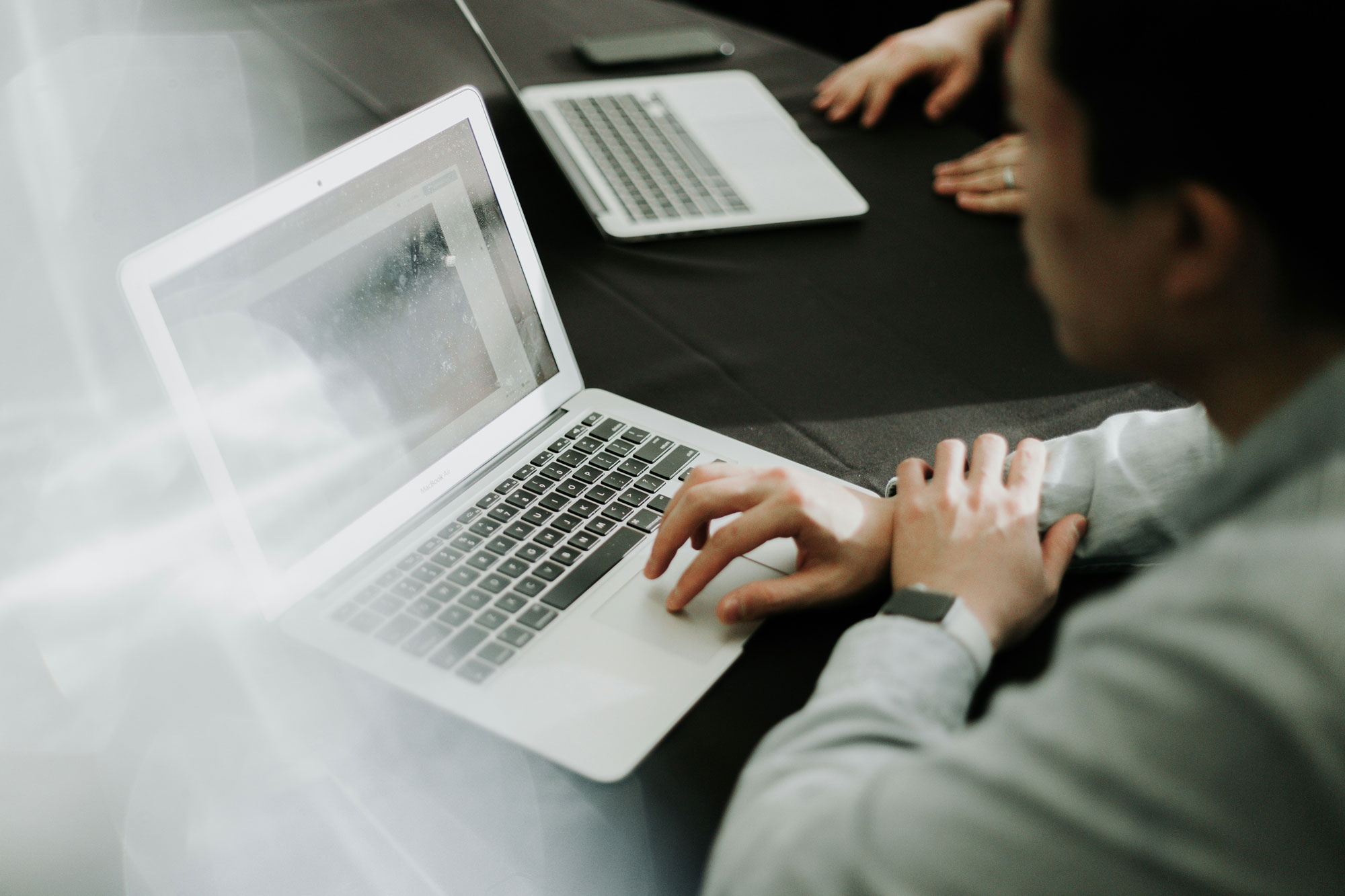 Zwei Personen arbeiten an einem Laptop